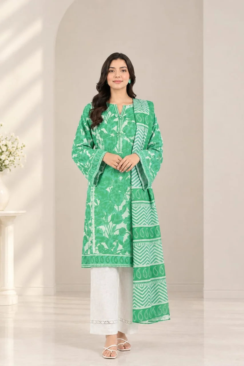 A woman modeling a green and white printed traditional kurta set with white pants, standing in a bright, minimalist interior setting.